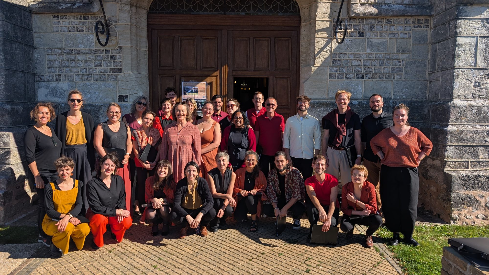 Les choristes des Oréades réunis devant le portail d'une église